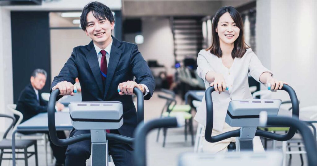 会社で運動をする男女